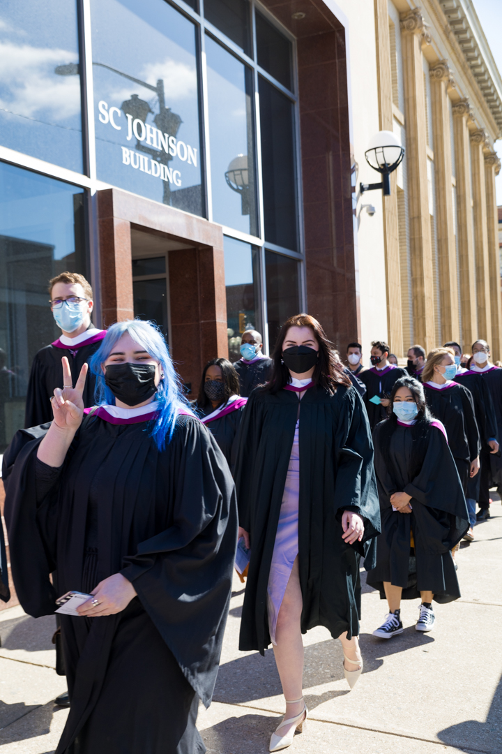 graduates wave during procession