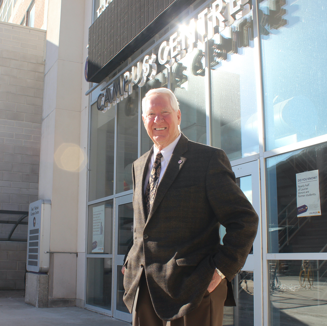 Photo of Fred Nicholas stands in the sunshine in front of the Student Centre.